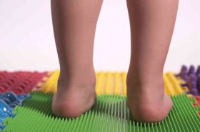 Children's legs close-up, valgus foot positioning. Examination of the child before the lesson on the orthopedic mat. High quality 4k footage